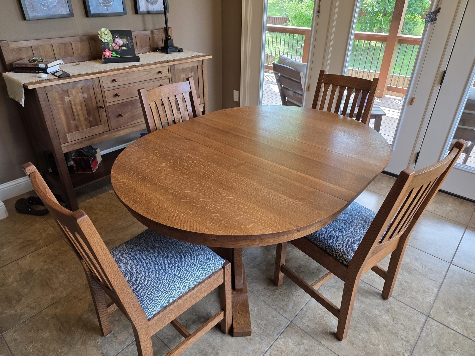 Refinished round oak dining table and matching chairs staged in the dining area